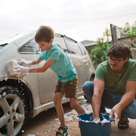 Father and son washing car. 