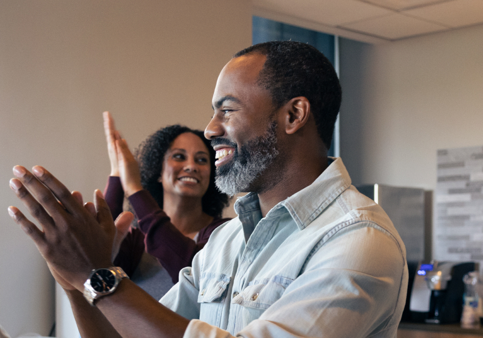 man and woman smiling with hands up. 