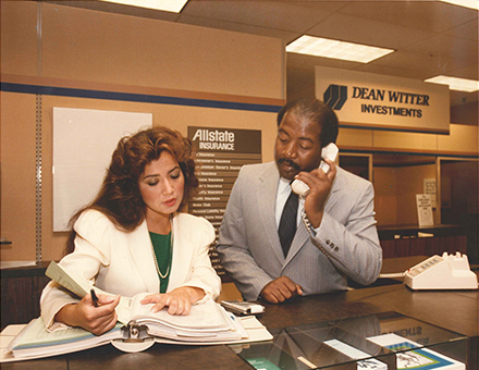 Woman and man behind a desk at an Allstate office. 