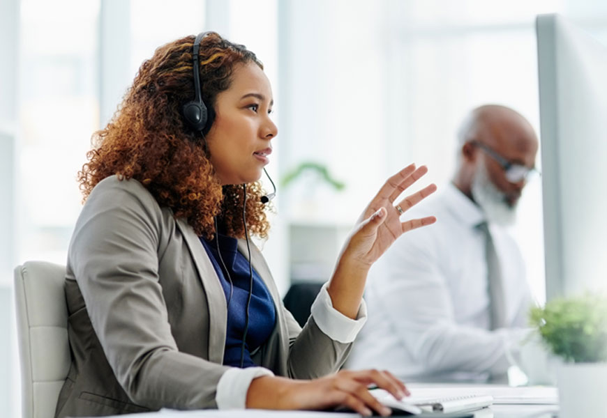 woman wearing headset looking concerned with her hand up. 