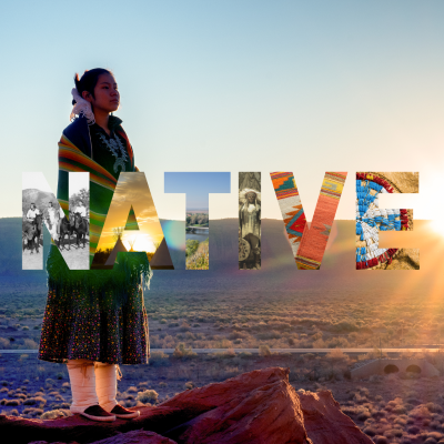 Native American person in ceremonial dress in the desert.  