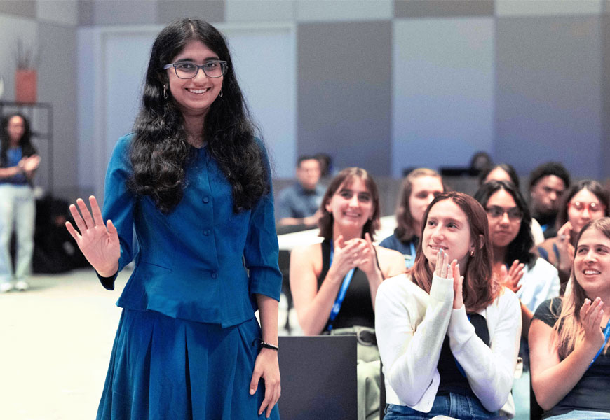 TIME's 2025 Kid of the Year Tejasvi Manoj smiling and waving at The Allstate Foundation Youth Service Summit. 